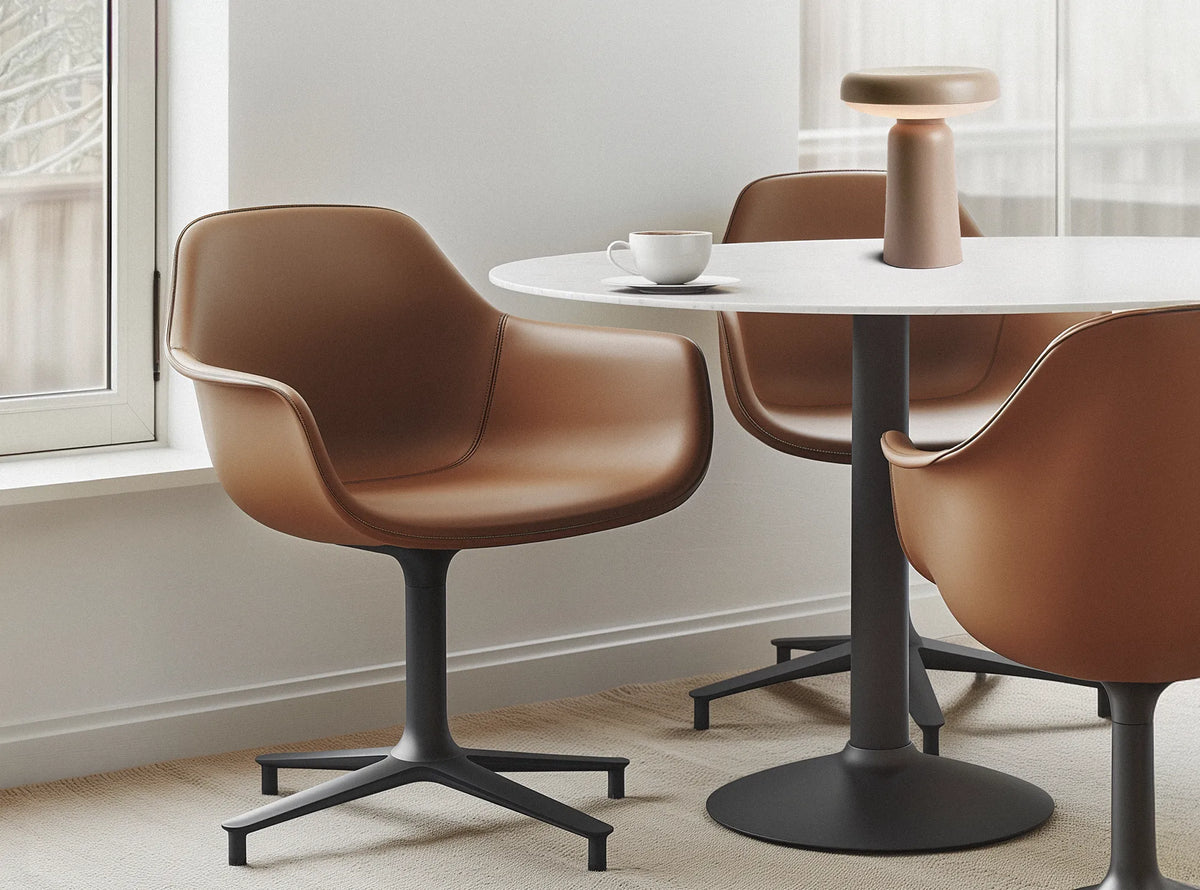 Dining chairs and a lamp arranged around a table